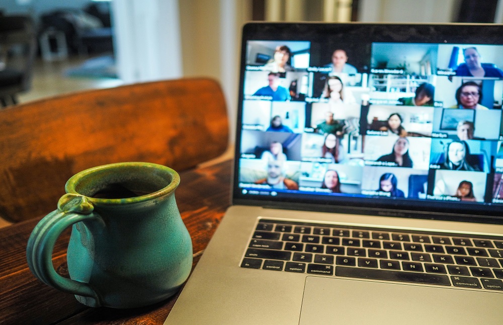 Photo of two employees talking to a woman on a video call